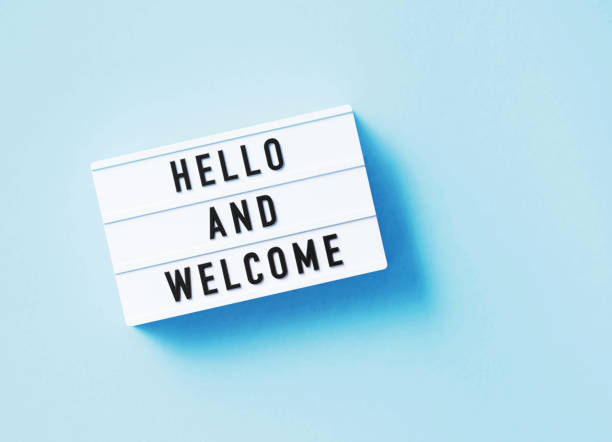 Hello and welcome written white lightbox sitting on blue background. Horizontal composition with copy space.  7 Creative Ways to Say Welcome
