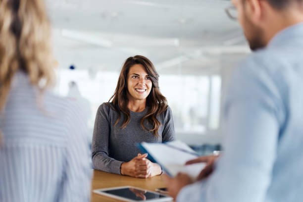 best interview scheduling software:Young female candidate talking to human resource team during a job interview in the office.