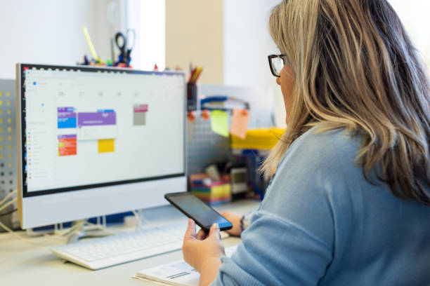 Femalein an office during a phone call, using online call scheduler to schedule appointments.