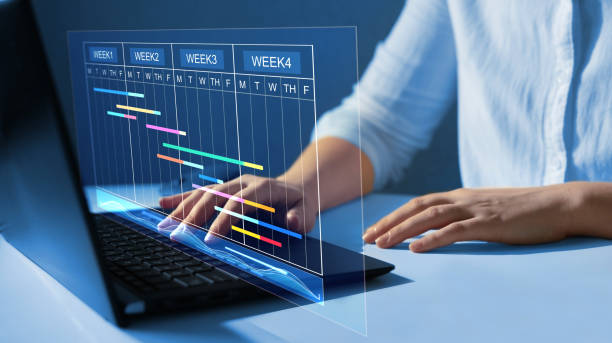 Project manager working on laptop and updating tasks and milestones progress planning with Gantt chart scheduling interface for company on virtual  screen. How to Fill Up Your Available Time Slots?